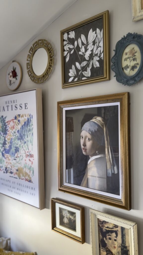 Eclectic gallery wall with vintage-style artwork and mixed frames.