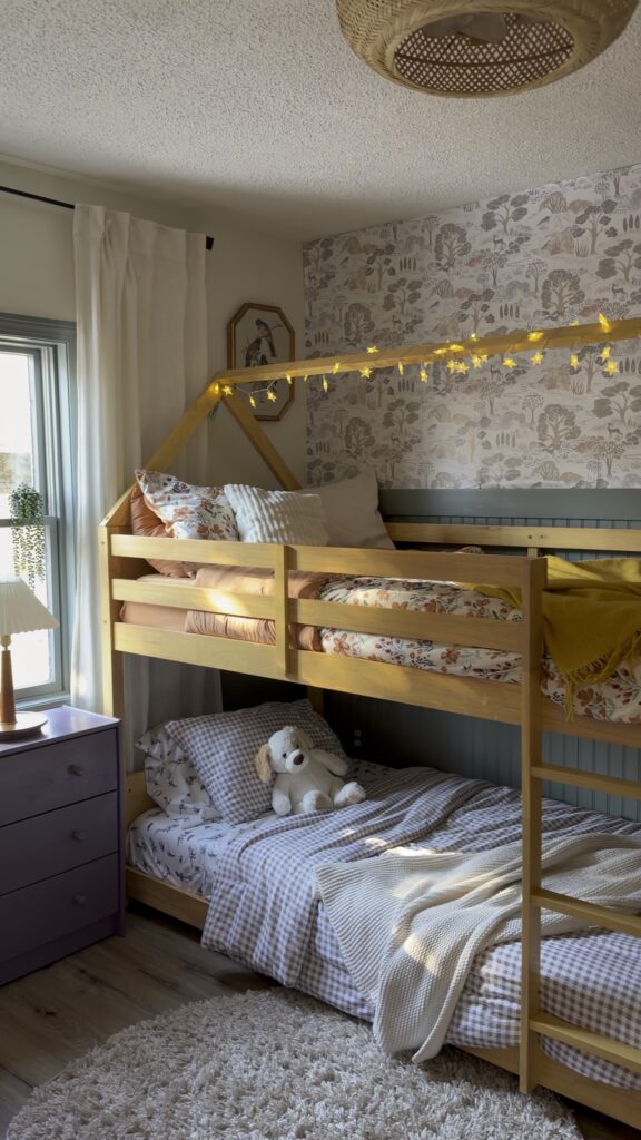 Warm and cozy shared children’s bedroom with bunk beds, soft lighting, and vintage-inspired decor