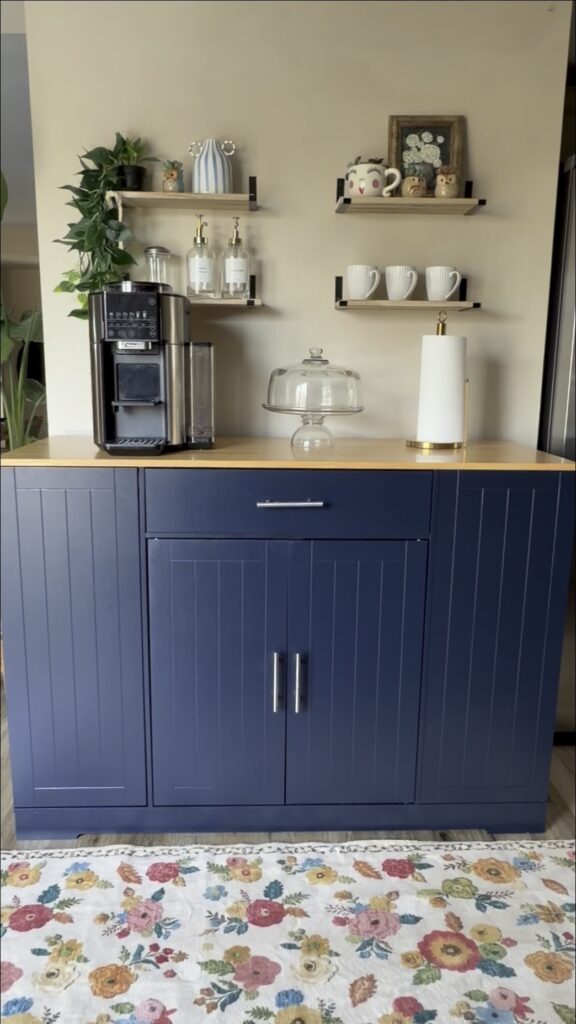 navy blue kitchen storage cabinet with countertop styled with coffee station and shelves
