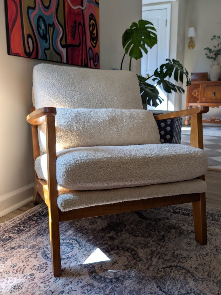 cozy cream accent chair with wood frame styled on patterned rug in living room