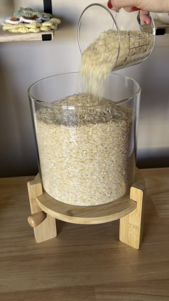 clear glass rice storage container on wood base styled on kitchen counter
