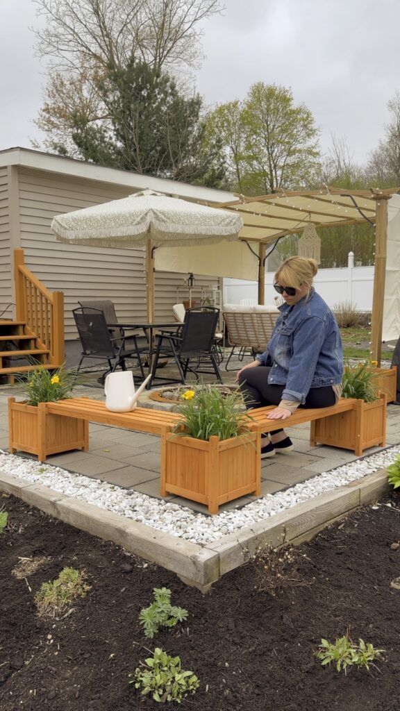 Outdoor wooden planter boxes with built-in bench seating on a backyard patio.