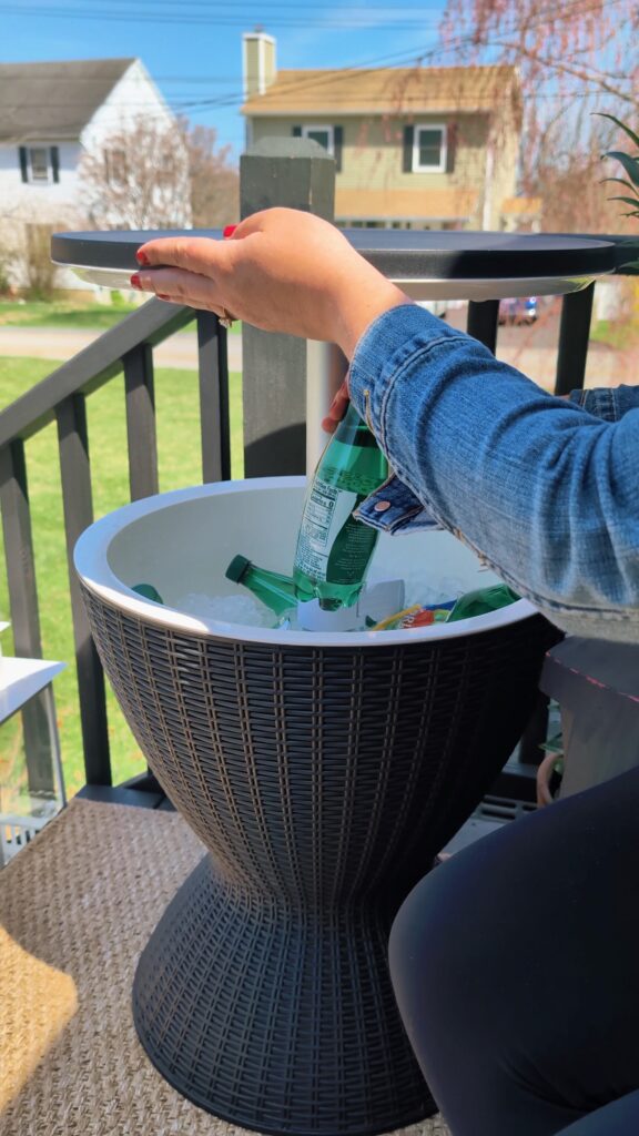 Outdoor wicker-style side table cooler being used on a backyard patio.