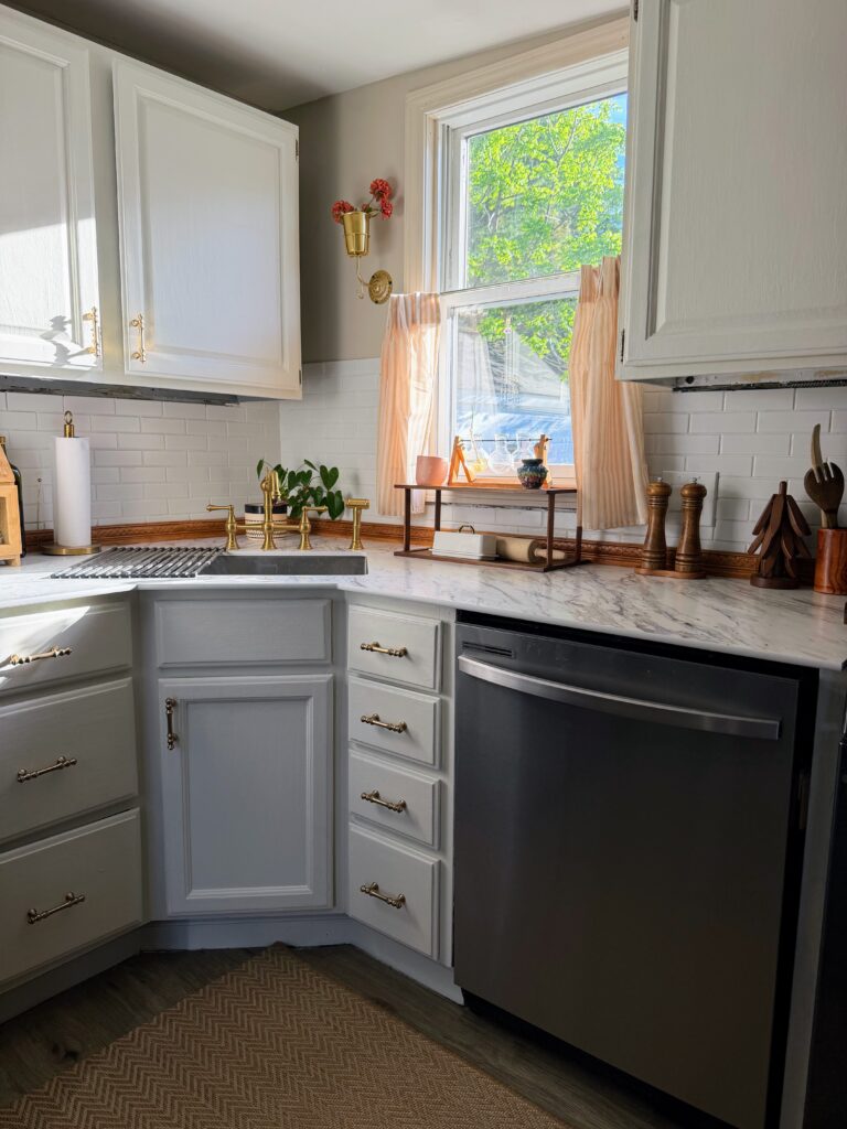 Cottage kitchen featuring cafe curtains, brass faucet, collected vintage-inspired decor
