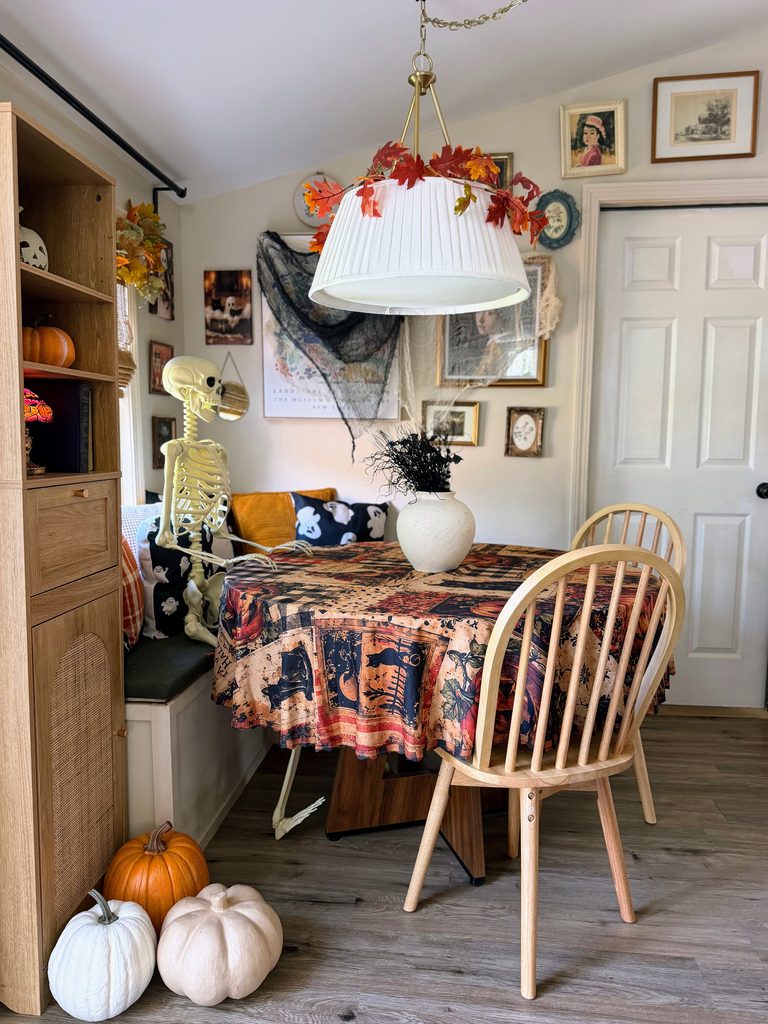 Halloween gallery wall decorated with vintage-inspired artwork and black and cream gauze above a cozy breakfast nook